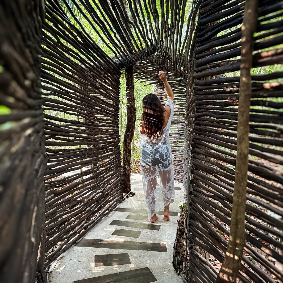 Guest walking through a woven wood jungle corridor
