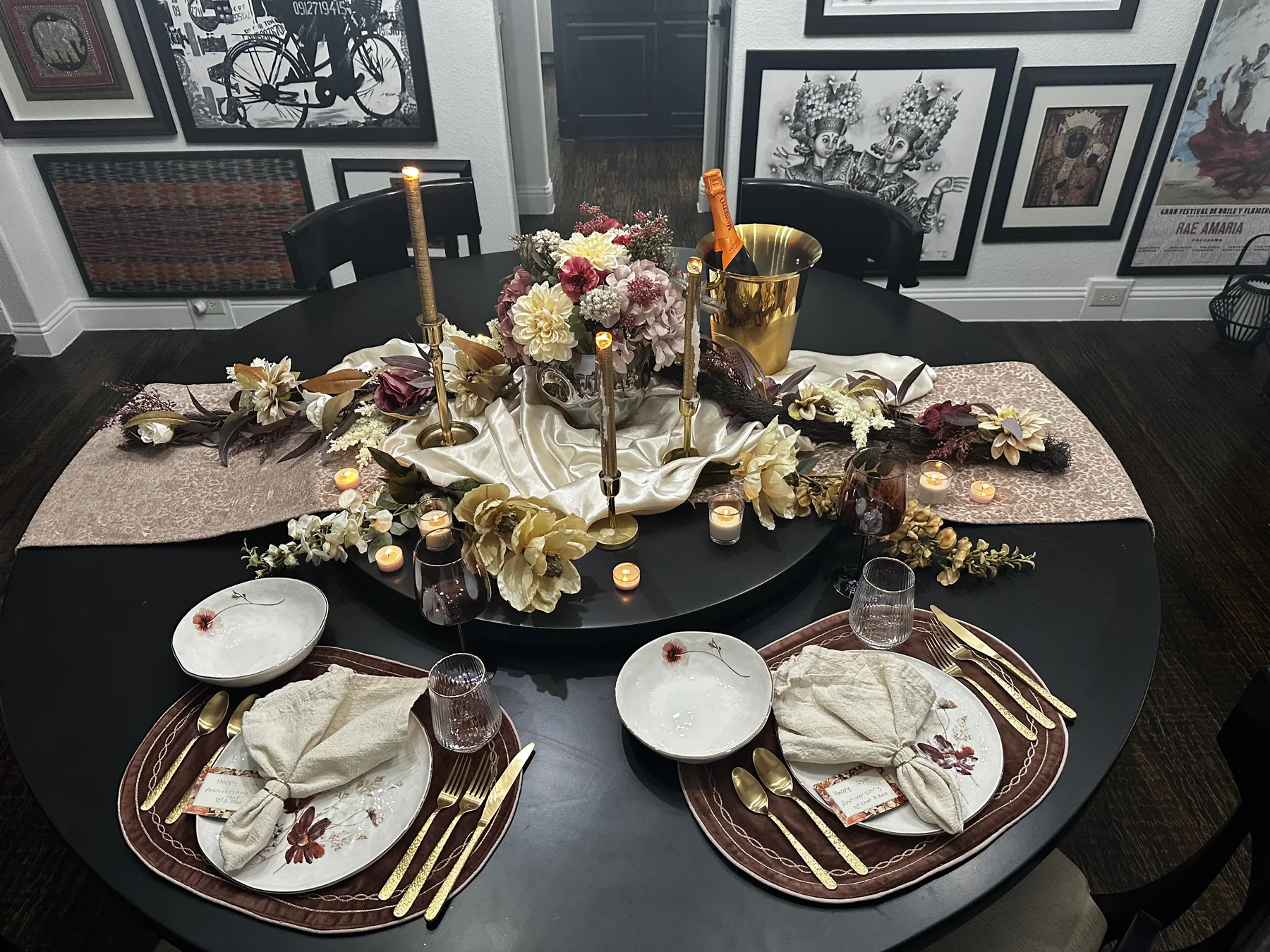 Romantic private dinner table for two styled with flowers, candles, and gold place settings